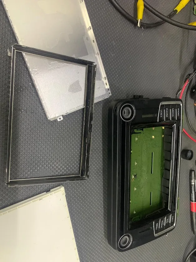 Radio original desmontada en banco de trabajo de Acevedo Serviauto para diagnóstico y reparación